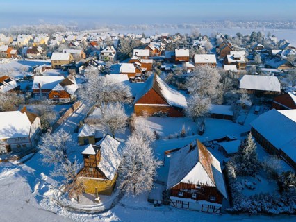 Winter village with snow-covered roofs and half-timbered buildings, cold, peaceful atmosphere,