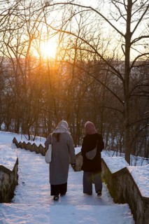 Two woman walk on snowy stairs with evening sun in Volkspark Friedrichshain on 07.01.2026
