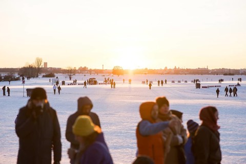 People stand at sunset on Tempelhofer Feld in Berlin on 11.01.2026