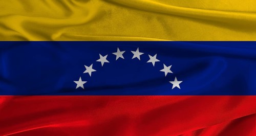 Flag of Venezuela with fabric textured background. Close up of National flag of Venezuela with