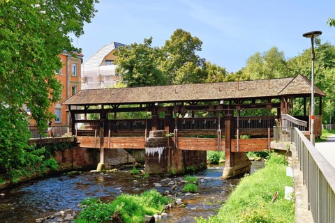Ettlingen, Germany - August 13th 2025: Old wooden bridge over the Alb river. Historic landmark on a
