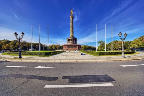 Victory column, roundabout, lantern, flagpoles, sidewalk, road, road markings lanes and direction