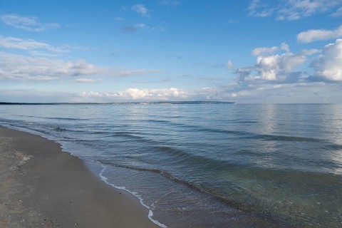 View across the Baltic Sea towards chalk coast, beach, sky with white clouds, Binz, seaside resort,