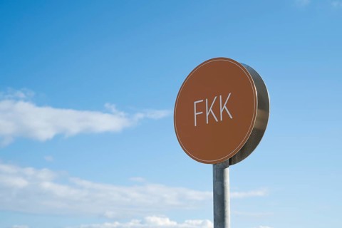 Naturist sign against blue sky with white clouds, Binz, seaside resort, Rügen island, Baltic Sea,