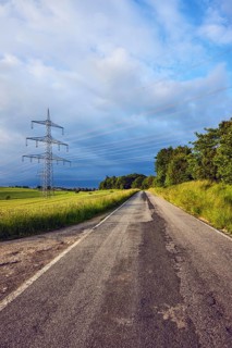 Landscape, road, high-voltage line, high-voltage mast, fields, trees, bushes, meadow, cloudy,