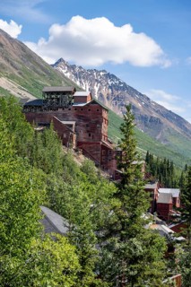Red Kennicott buildings in front of mountainous landscape, Kennicott Concentration Mill to extract