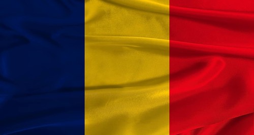 Flag of Chad with fabric textured background. Close up of National flag of Chad with realistic