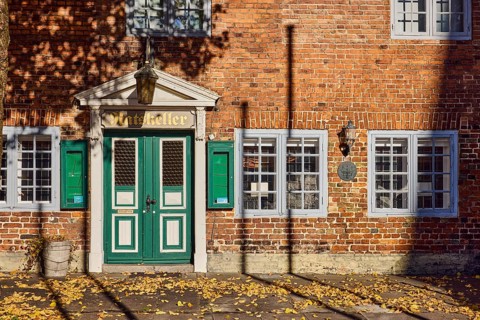 Historic Ratskeller restaurant, brick building, entrance, façade with windows and lamp, fallen