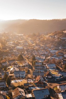View of a village in winter at sunrise with snow-covered roofs and a golden atmosphere, Glatten,