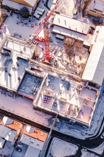 Detailed view of a snowy construction site with visible building materials, Zellerschule new