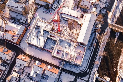 Bird's eye view of a snowy construction site between urban houses, Neubau Zellerschule, Nagold,