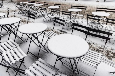 Winter in Stuttgart. Outdoor dining chairs and tables are covered with snow. Geometric structures.