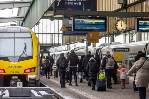 Travelers in the main train station, passengers in front of a regional train from Arverio.
