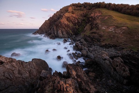 Sunset, Byron Bay, New South Wales, Australia. Waves crashing on rocks at the most easterly point
