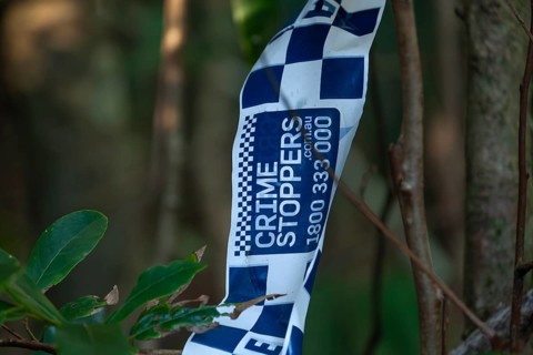 Crime scene, Byron Bay, New South Wales, Australia. Police tape blocks a forest path during an