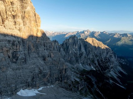 Aerial view, alpine panorama, rocky peaks at sunrise with alpine glow, picturesque mountain