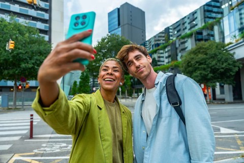 Smiling multiracial young adults enjoying a moment together outdoors, capturing a selfie with a