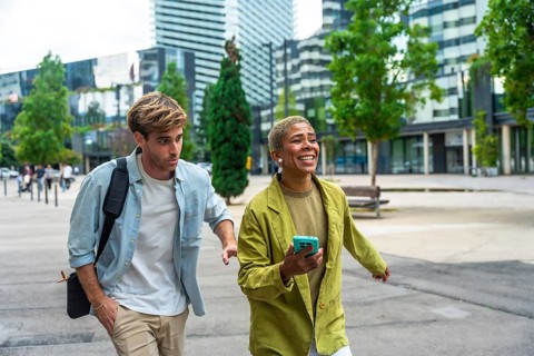 Diverse business colleagues walking on a paved pathway outdoors in a modern city district, sharing