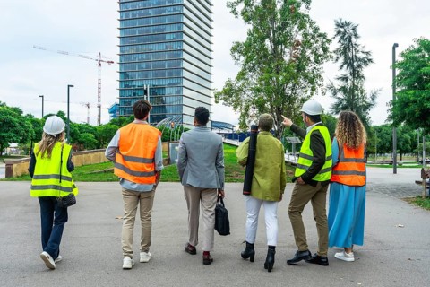 Diverse group of architects, engineers, and construction professionals walking and discussing plans
