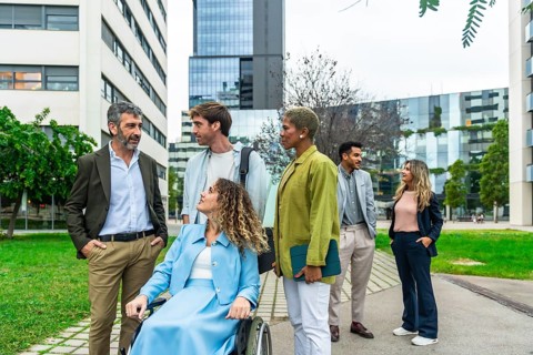 Group of diverse business professionals, including a woman using a wheelchair, collaborating and