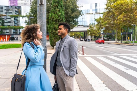 Diverse business professionals having a discussion while standing on an urban street near a