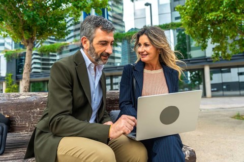 Mature business professionals, man and woman, discussing project ideas and networking on a park