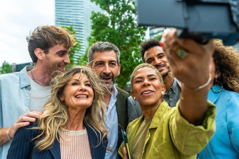 Diverse group of smiling business people and colleagues enjoying a moment together, taking a selfie