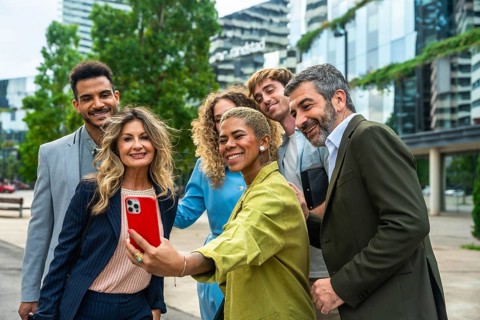 Diverse group of smiling business professionals and colleagues posing together for a group selfie