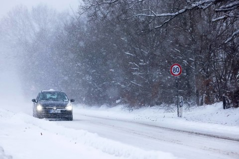 Road traffic in winter, car driving on heavily icy road covered with snow and black ice in a