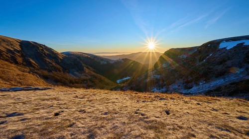 Frosty mountain landscape at sunrise with bright sunlight and clear sky, winter, Route de Cretes,