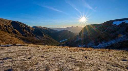 Frost-covered mountain landscape at sunrise with clear sky and bright sunlight, winter, Route de
