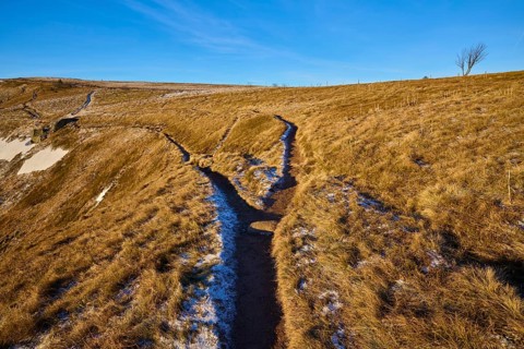 A forked path through grassy hills with blue skies and wintry atmosphere, La Gorge de Pierrel,