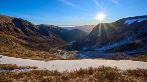 Snowy valley at sunrise with clear blue sky and bright sunbeams, winter, Route de Cretes, Hohneck,