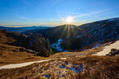 Sunrise over a snow-covered valley surrounded by mountains and rocks, winter, Route de Cretes,