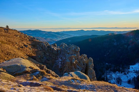Quiet mountain landscape with rocks in the foreground and blue sky in the background, view of the