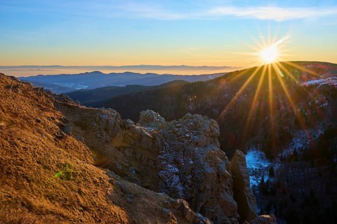 View of a rock formation illuminated by the low sun in the mountains, looking towards the Rhine