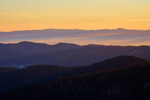 Mountains in silhouette at sunrise in warm shades of orange and yellow, view, Rhine Valley,