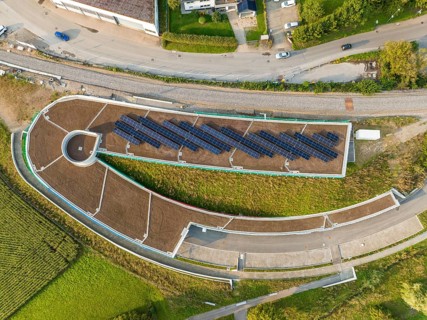 Aerial view of a solar cell field on a roof with surrounding roads, new Park and Ride parking