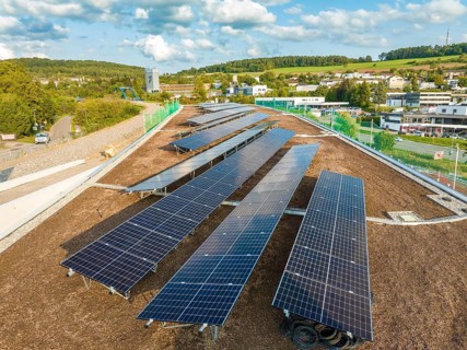 Arrangement of solar modules in a rural area with houses and hills, new park and ride parking