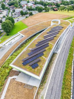 Roof with solar systems near roads and train lines, nestled in nature, new park and ride parking