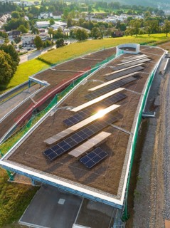 A roof area with solar panels, illuminated by the evening sun, in a rural area, new park and ride
