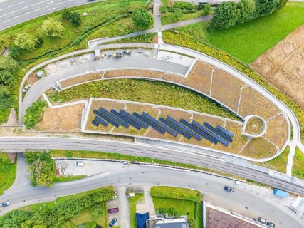 Large solar systems on a covered parking lot surrounded by roads and greenery, new Park and Ride