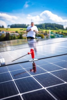 Close-up of a solar module with a working person in a rural area, new Park and Ride parking garage