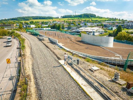 Large construction site for solar systems next to a village with green hills in the background, new