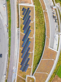 Aerial view of solar roof area in an urban area with plants and paths, new park and ride parking