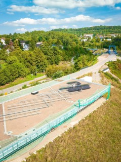 Aerial view of a construction site with solar system and surrounding green landscape in the