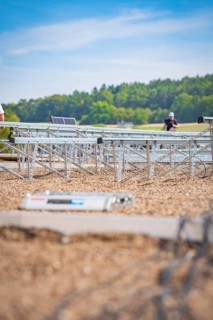 Workers prepare to install solar panels in an open field, new park and ride Calw Heumaden car park