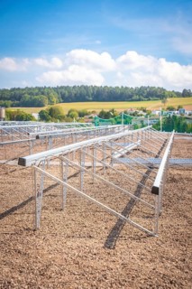 Metal structures for solar panels in an open field under a blue sky, new park and ride car park