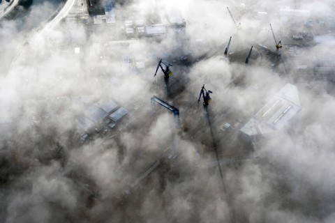 Blohm and Voss, Lürssen shipyard, cranes looking out of the fog, Hamburg, Elbe, Germany,