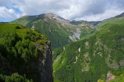 Green mountains under blue sky with clouds, peaceful summer day in nature, mountainous landscape